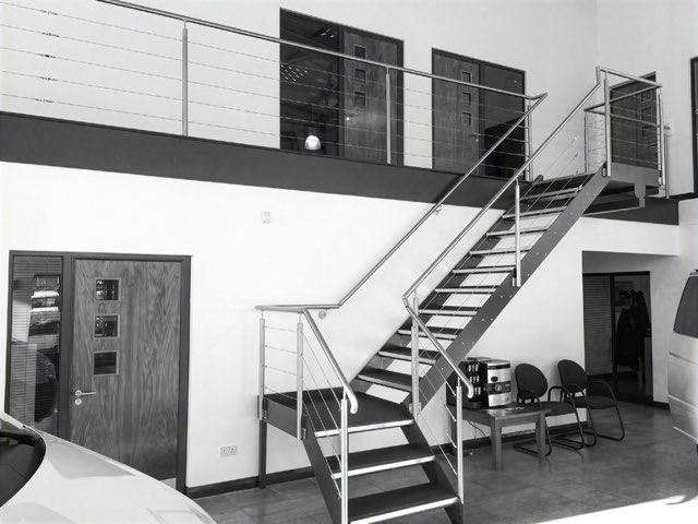 Stainless steel staircase with cable balustrade in a commercial showroom